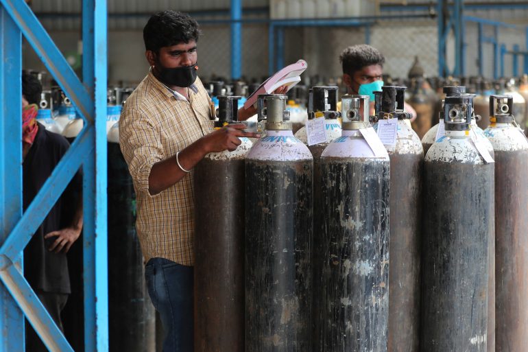 A worker checks oxygen cylinders before they are delivered to different hospitals at a gas supplier facility in Bengaluru, India, Wednesday, April 21, 2021. India has been overwhelmed by hundreds of thousands of new coronavirus cases daily, bringing pain, fear and agony to many lives as lockdowns have been placed in Delhi and other cities. Prime Minister Narendra Modi tried to boost spirits in a nationwide address on Tuesday night by saying the government and the pharmaceutical industry were stepping up efforts to meet the shortages of hospital beds, oxygen, tests and vaccines. (AP Photo/Aijaz Rahi)